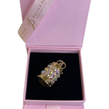 Gold cylindrical charm adorned with iridescent Swarovski crystals, displayed inside a black velvet-lined light pink jewelry box with Alysa Payne Beverly Hills branding.