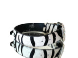 Black and white tiger print hair-on-hide leather pet collar with sparkling Swarovski crystal buckle, shown with reflective surface underneath and white background.