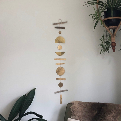 Adrift Mobile wall hanging detailed view showing three driftwood pieces and hammered brass accents