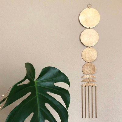 Here Comes the Sun brass wall hanging by Vida + Luz on a neutral wall