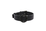 Black leather collar featuring a circular ring adorned with black crystals, shown against a white background from a slight side angle.