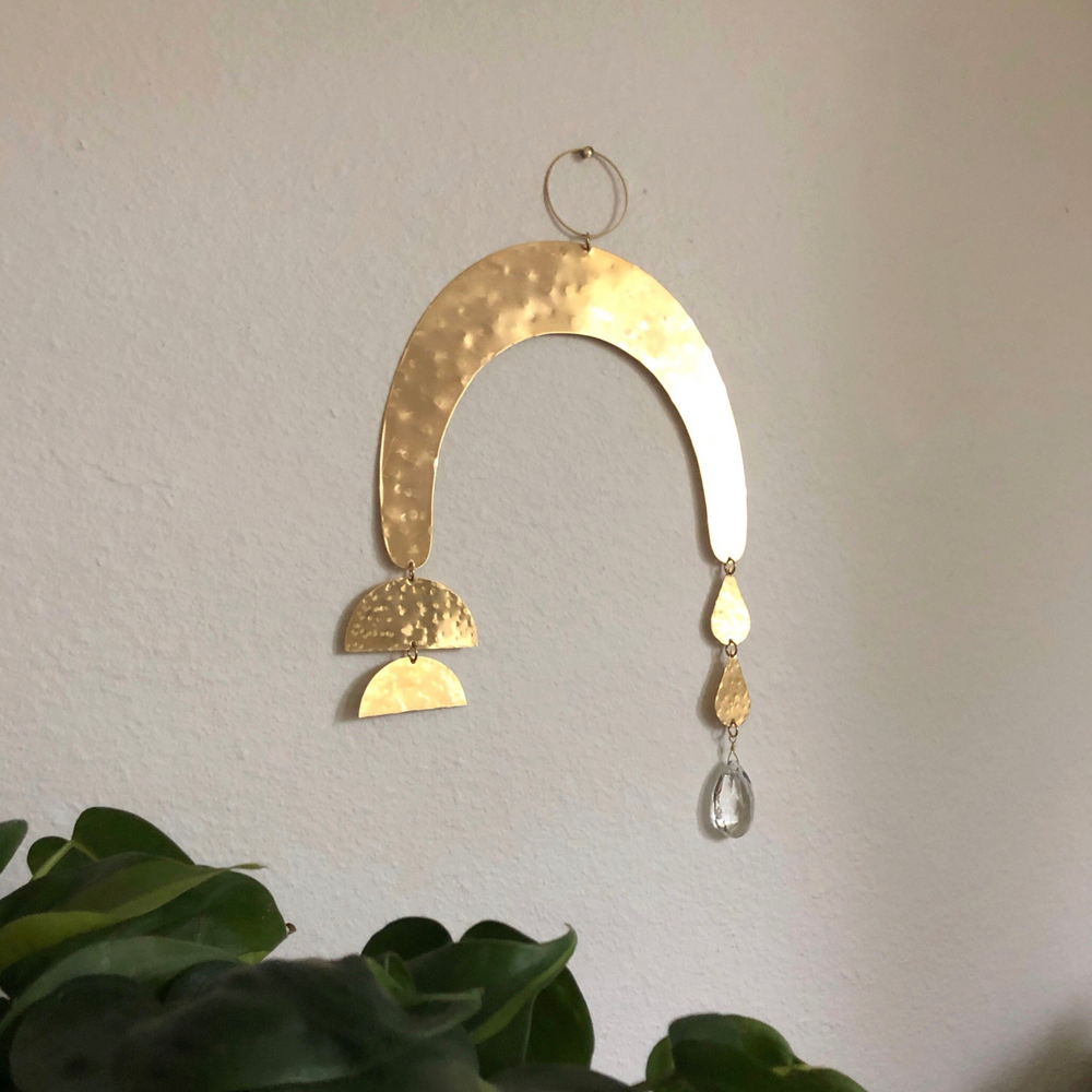 Promesa Suncatcher hanging showing hammered brass and vintage glass crystal casting colorful prisms