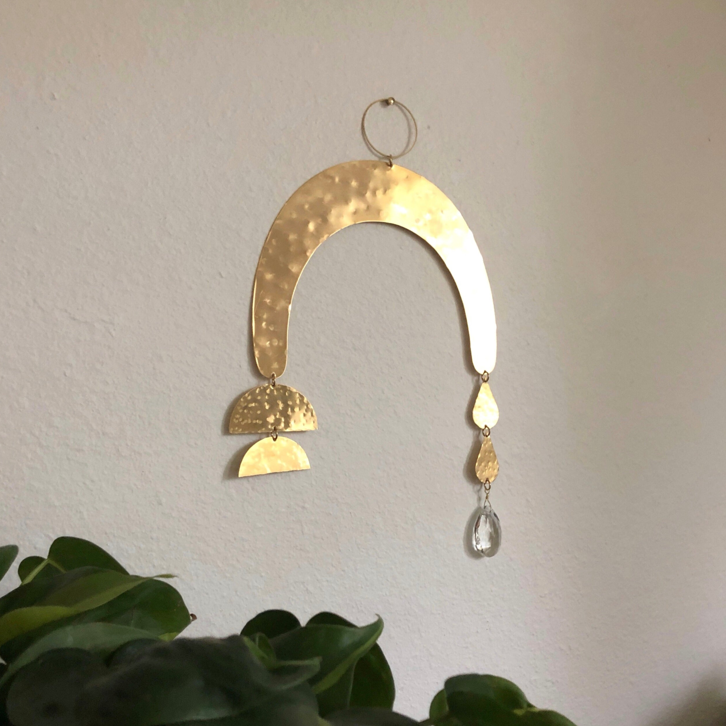 Promesa Suncatcher hanging showing hammered brass and vintage glass crystal casting colorful prisms