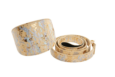 Luxury pet collar and leash set with snakeskin pattern laid on white stone and dark fabric