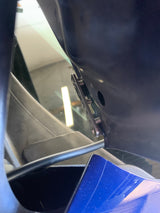 Close-up view of a metal universal clamp-on ditch light bracket attached to a vehicle frame, with visible bolts and a black electrical cable.