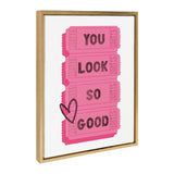 Four vertically stacked bright pink raffle tickets with black text reading 'YOU LOOK SO GOOD' and a hand-drawn black heart on the left side, framed in light wood.
