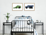 Two framed vintage toy vehicle illustrations—green tractor and blue dump truck—hung above a black metal bed with blue and gray ball string lights and white bedding.