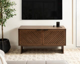 Rectangular wooden TV stand with two diagonally slatted cabinet doors and sleek dark handles, standing on a matching base with minimal decor on top.