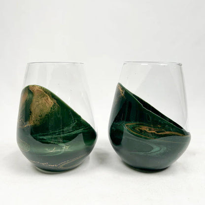 Two green marbled stemless resin wine glasses on a white background