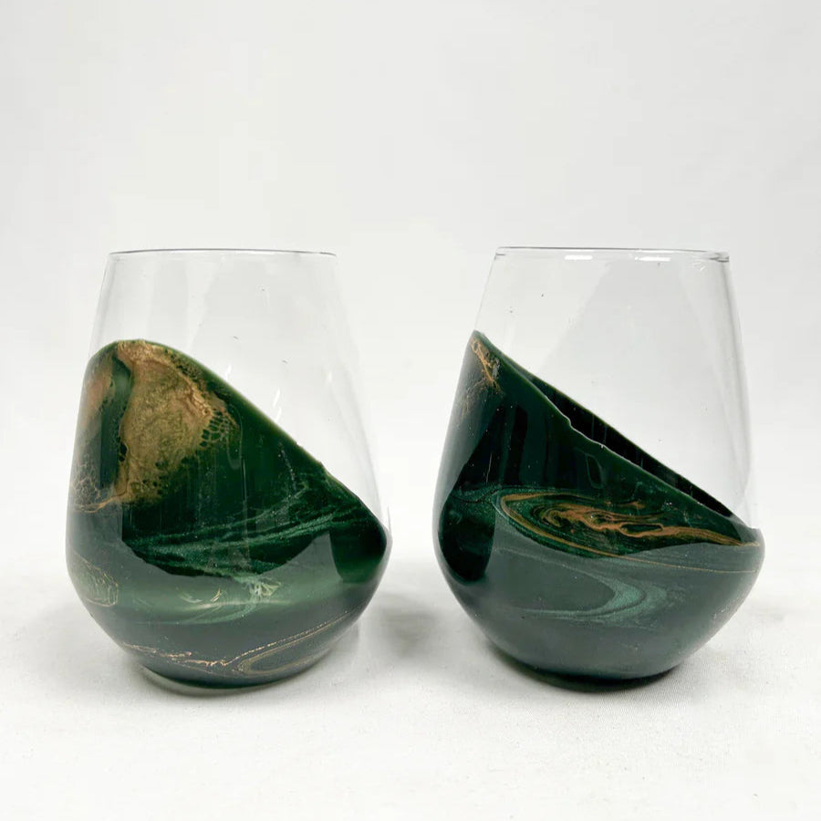 Two green marbled stemless resin wine glasses on a white background