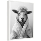 Black-and-white portrait of a sheep facing forward, wearing a soft white bathrobe with a fluffy textured collar, set against a plain light background.