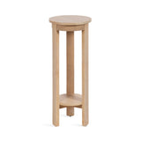 Tall round wood side table with a light natural finish, featuring three straight legs connected by a circular lower shelf.