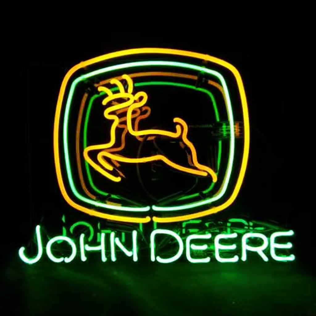 Neon sign of John Deere logo with a yellow leaping deer inside a green square frame above glowing green text 'JOHN DEERE' on black background
