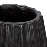 Close-up of a black cylindrical planter with textured vertical ridges and a slightly scalloped rim
