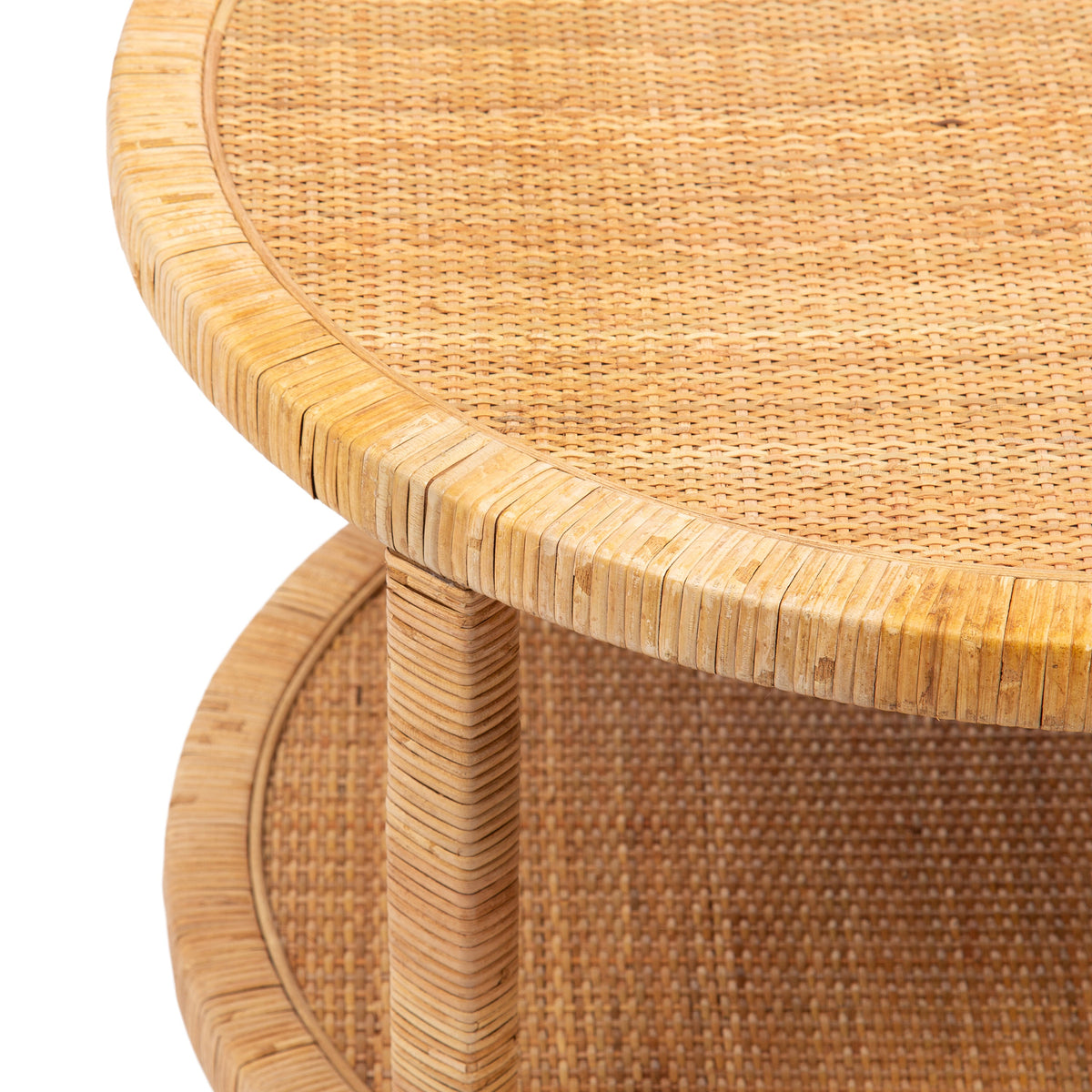 Close-up of round rattan table with woven textured surface and wrapped rattan edges and legs in natural beige tones.