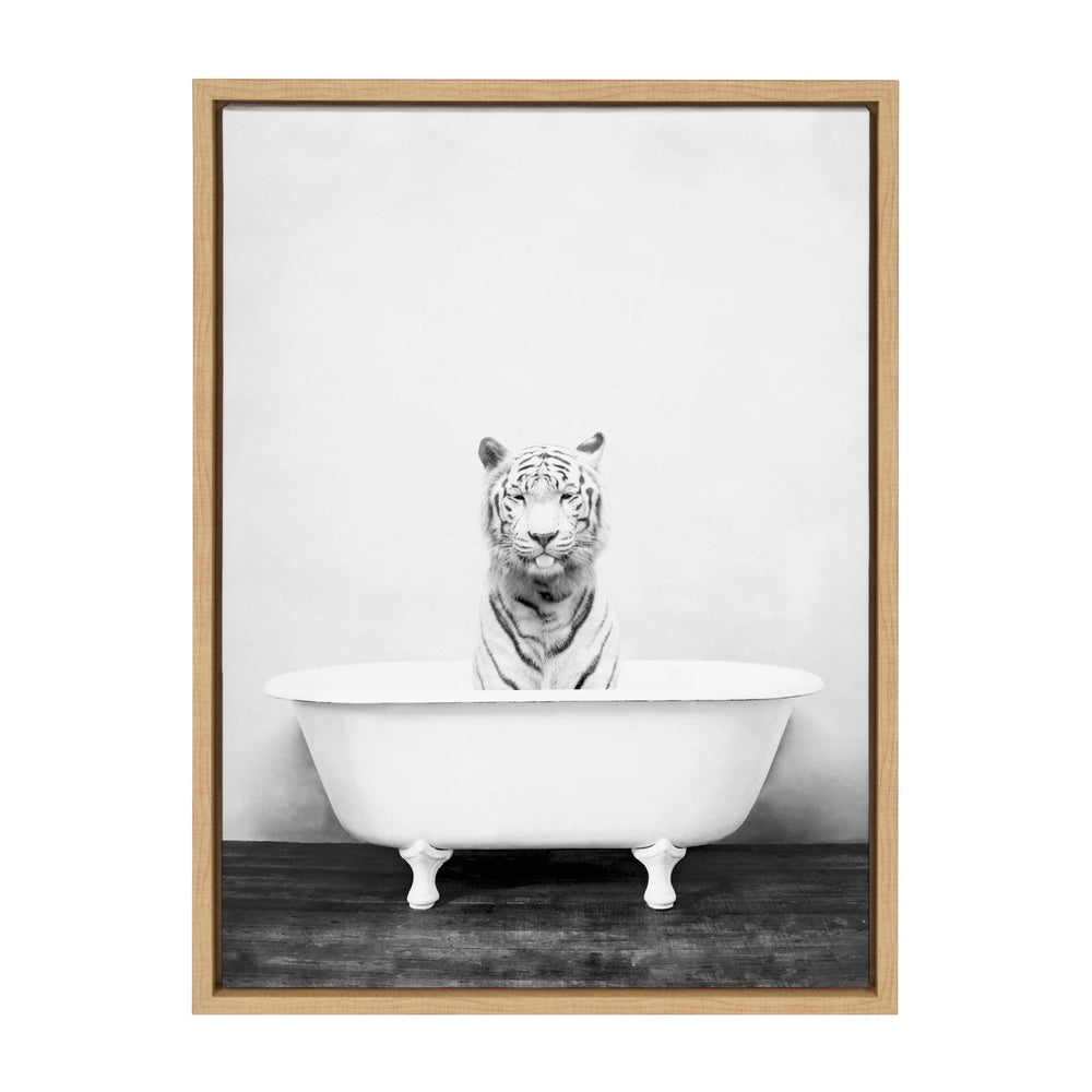 Black and white photo of a white tiger sitting inside a clawfoot bathtub against a plain wall and wooden floor, framed in a light wooden frame.