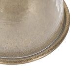 Close-up of translucent beige glass dome with subtle floral pattern and textured rim resting on a matching base plate.