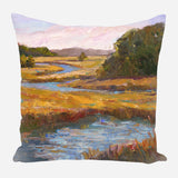 Pillow featuring an impressionistic painting of a winding blue river flowing through vibrant golden marshland with dark green trees under a soft pink and lavender sky.
