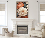Framed canvas featuring large ivory and peach peony flowers with dark green leaves above a white fireplace in a neutral-toned living room with patterned cushions and woven basket.