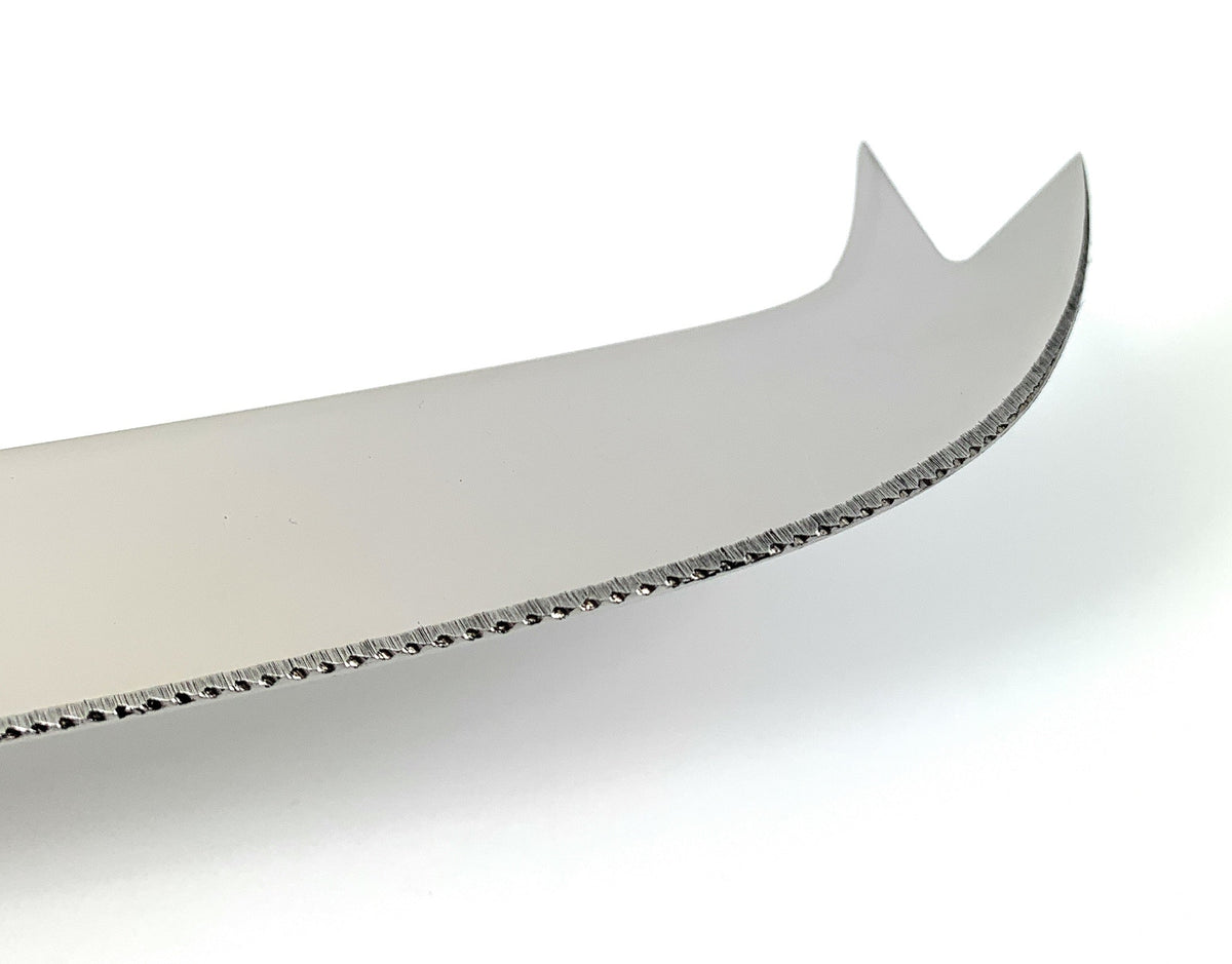 Close-up of a stainless steel cheese knife blade with a curved handle and serrated edge, featuring a forked tip for picking up cheese