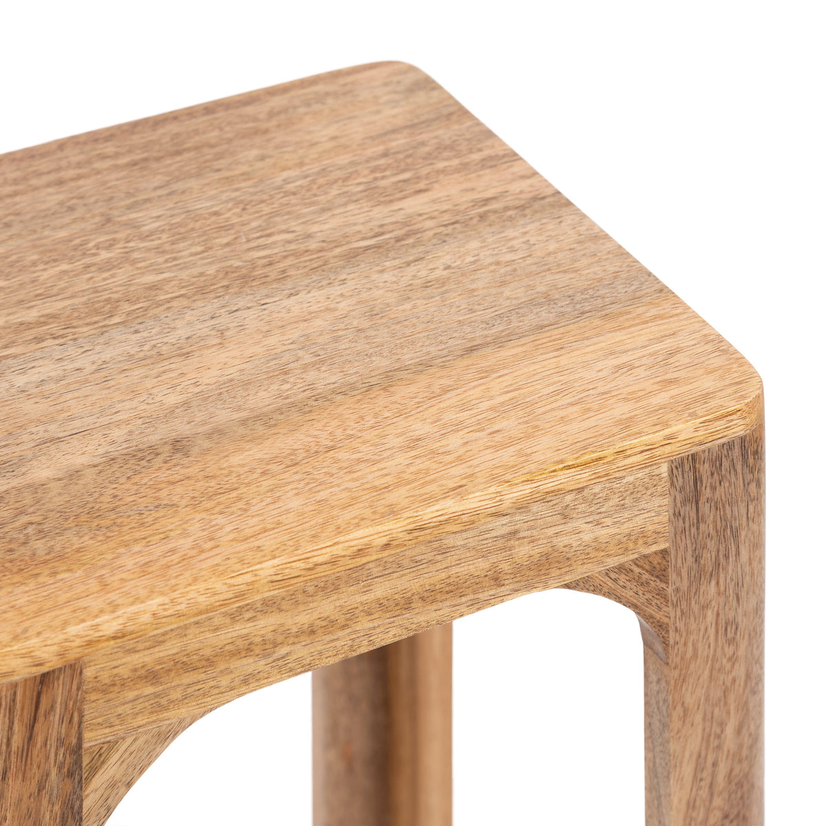 Close-up of a square wooden tea table corner with smooth rounded edges and visible natural wood grain texture in light brown tones.