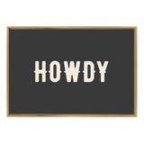 Black rectangular canvas with the word HOWDY in bold, cream-colored western-style letters, framed by a thin light wood frame.