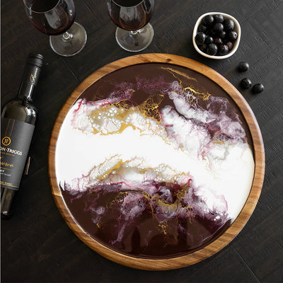 Round acacia wood lazy susan with hand-poured resin design, shown with snacks and drinks on a table