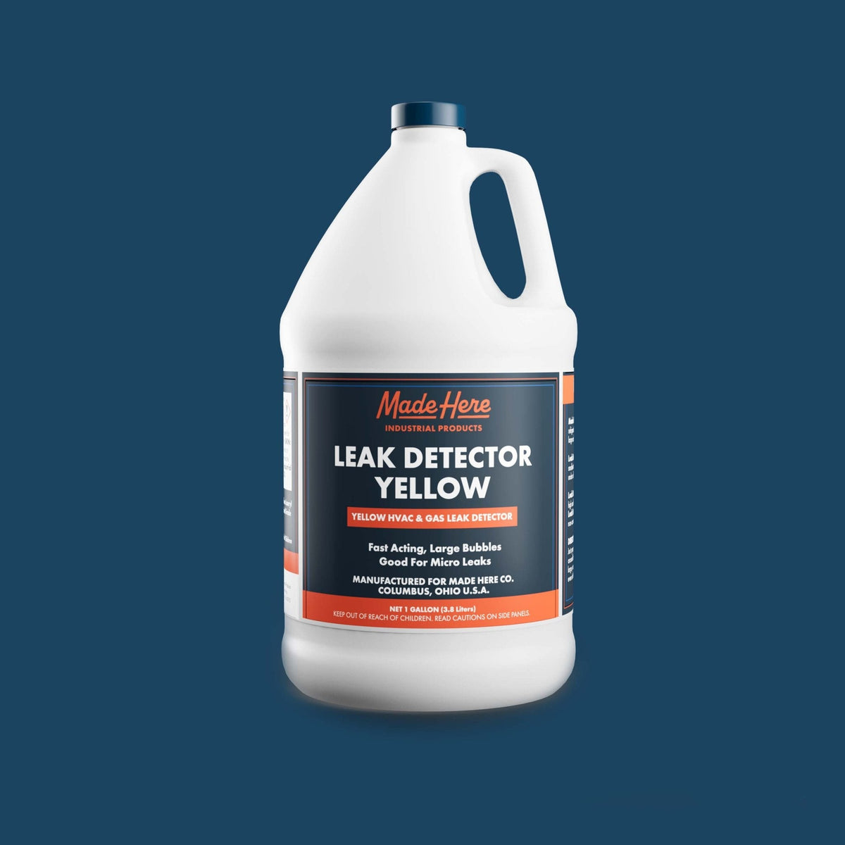 White plastic gallon jug with handle containing Made Here Leak Detector Yellow, featuring a dark blue and orange label with product details