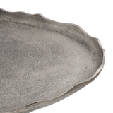Close-up of an oval coffee table surface with a textured gray finish and irregular, uneven edges creating a natural organic shape.