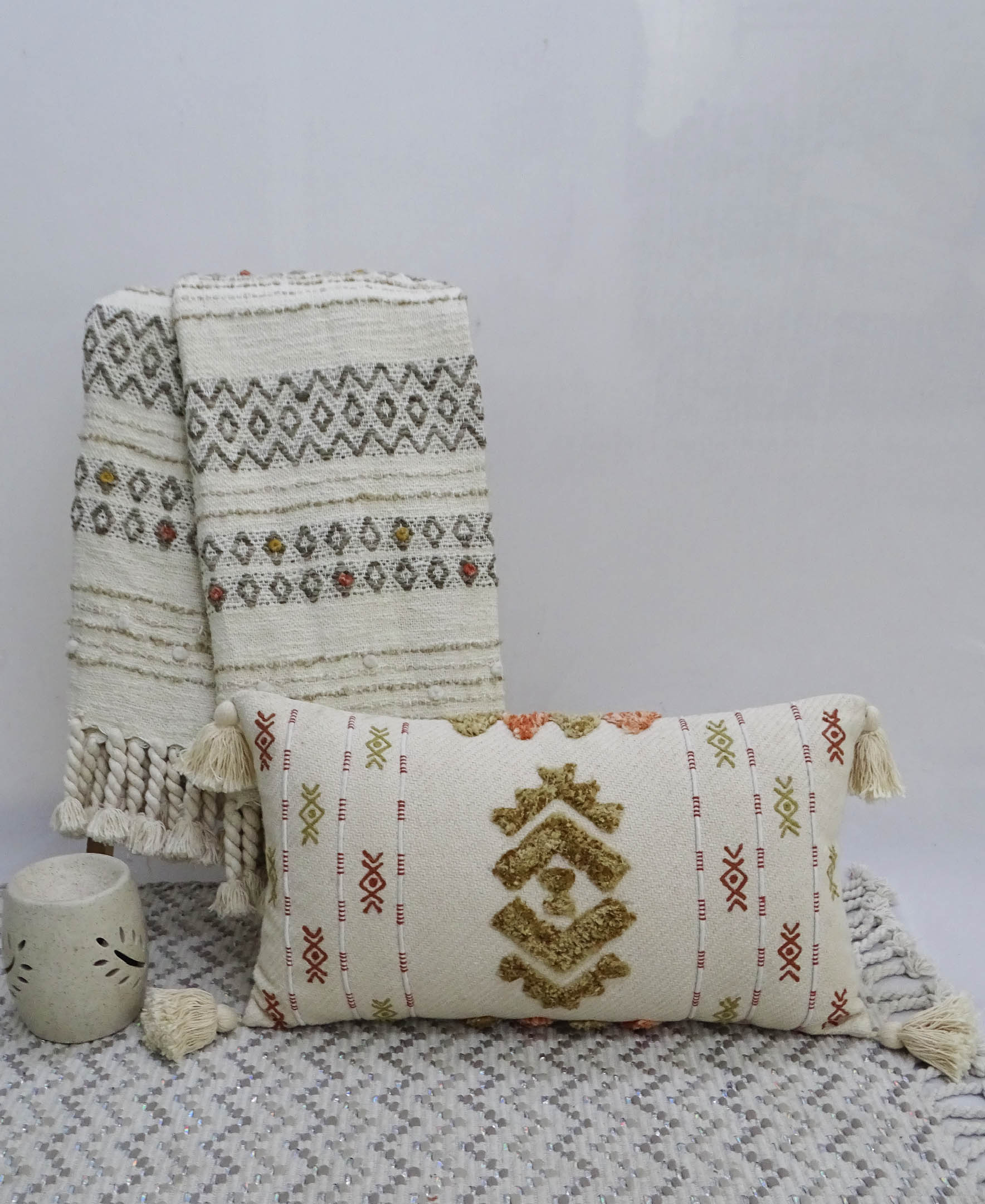 Colorful embroidered throw pillow with tassels displayed on beige furnishings