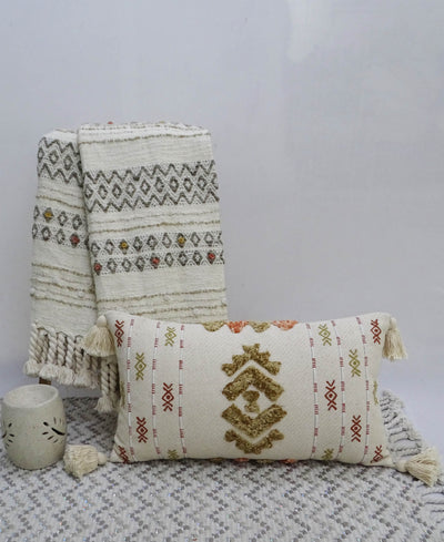 Colorful embroidered throw pillow with tassels displayed on beige furnishings