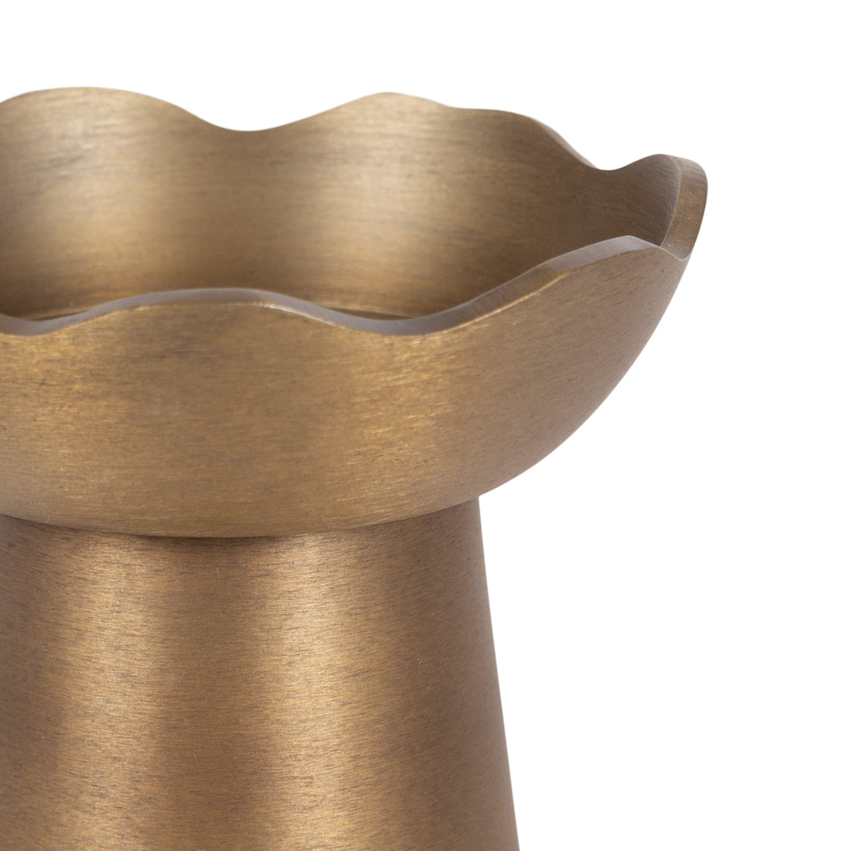 Close-up of a bronze-colored metal pillar candle holder with a scalloped, flower-like rim and a brushed finish.