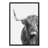 Black and white portrait of a Highland cow facing forward with long shaggy hair partially covering its eyes and a single curved horn extending leftward.