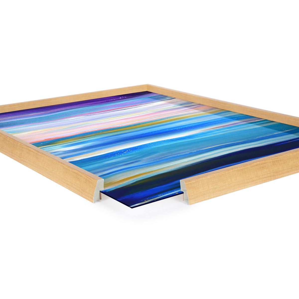 Framed artwork titled Blake Seaside Serenity by Xizhou Xie featuring horizontal streaks in vibrant blue, purple, and white hues, partially viewed at an angle on white background.