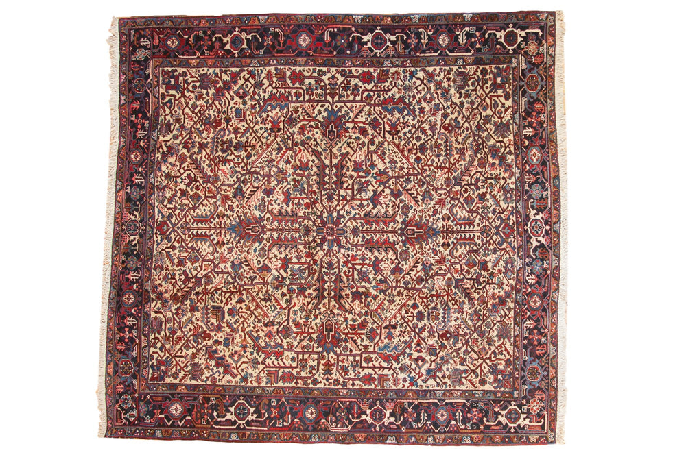 Square vintage Mehrivan carpet with an intricate geometric floral pattern in muted reds, blues, and creams, framed by a dark detailed border with floral motifs.