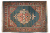 Vintage 10x13.5 Serapi Indian Soumac carpet with central medallion in muted coral and beige on a blue field, framed by intricate geometric borders.