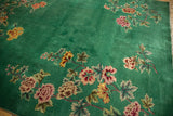 Green rectangular vintage Nichols Art Deco carpet featuring scattered floral clusters in pink, yellow, and beige along with green leaves on a solid green background.