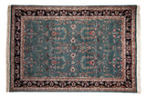Rectangular vintage Indian carpet with a teal central field featuring intricate floral and geometric patterns, surrounded by a dark brown border with light pink and cream floral motifs.