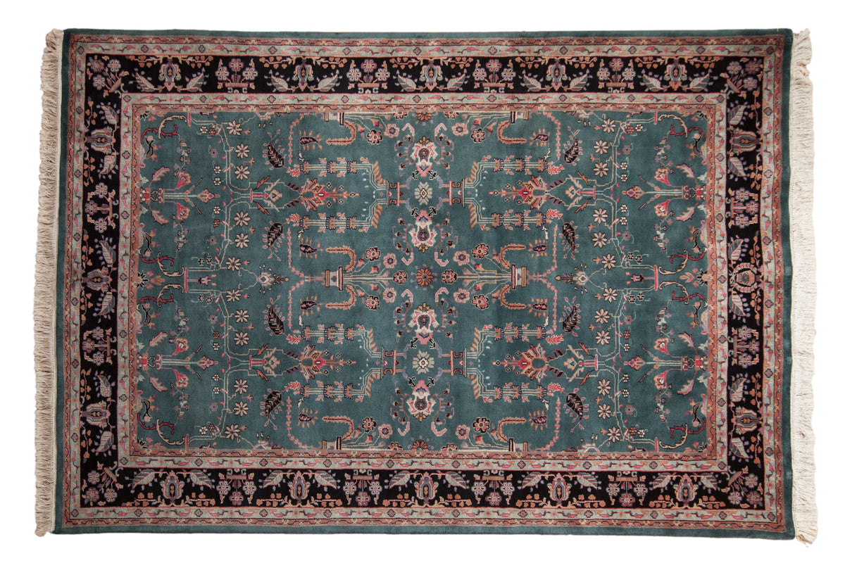 Rectangular vintage Indian carpet with a teal central field featuring intricate floral and geometric patterns, surrounded by a dark brown border with light pink and cream floral motifs.
