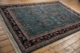 Rectangular vintage Indian Mohajeran Sarouk carpet with teal central field and intricate floral and vine motifs, framed by a dark floral border, displayed on wooden floorboards.