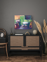 Colorful canvas painting depicting an interior with a green door, round table, chairs, and vibrant brushstrokes, hung above a black cabinet with woven panels.