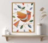 Framed artwork of a stylized cardinal bird perched on branches with multicolored geometric leaves, featuring warm fall tones and a clean white background.