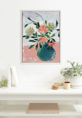 Framed Sylvie Beaded Wild Blooms painting by Nikita Jariwala with colorful flowers in a blue vase against soft pink and white background, hanging above a white shelf with decor.
