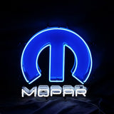 Blue neon Mopar logo shaped like a stylized 'M' with white neon text spelling 'MOPAR' underneath against a black background.