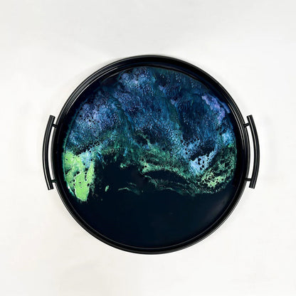 Round resin tray with a green and blue abstract design on a white background