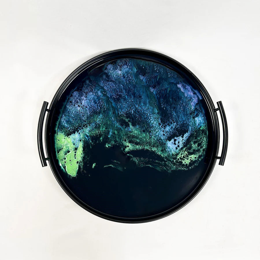 Round resin tray with a green and blue abstract design on a white background
