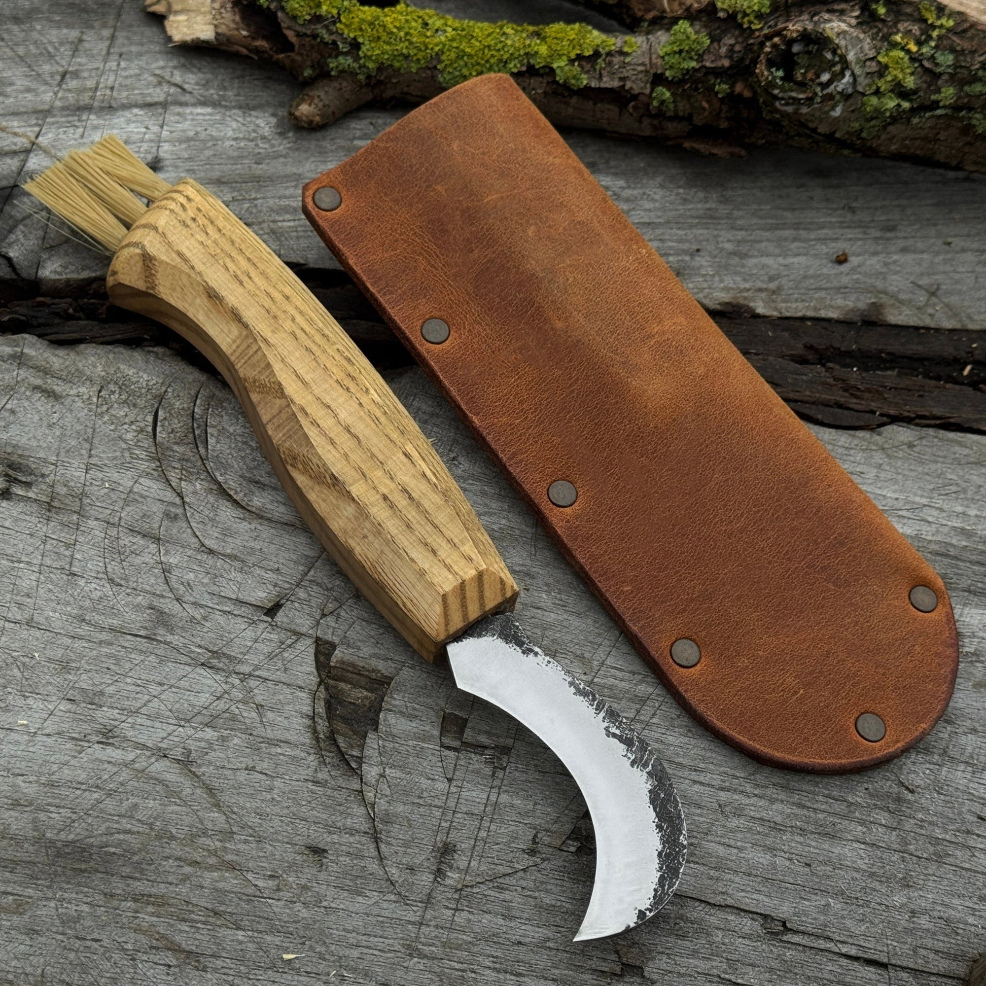Mushroom knife with carbon steel blade, ash wood handle, and built-in brush, shown with leather sheath