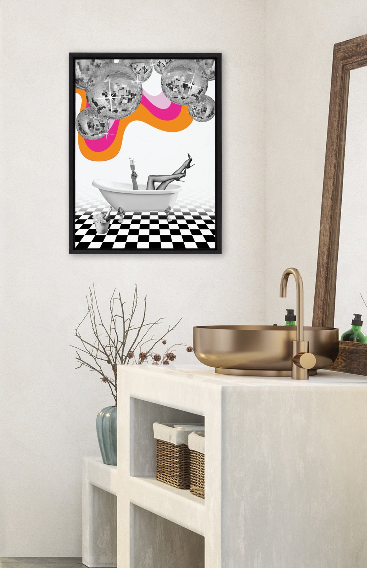 Framed canvas above bathroom sink shows a surreal scene with a person lounging in a white bathtub on a black-and-white checkerboard floor, disco balls, and colorful wavy stripes above.