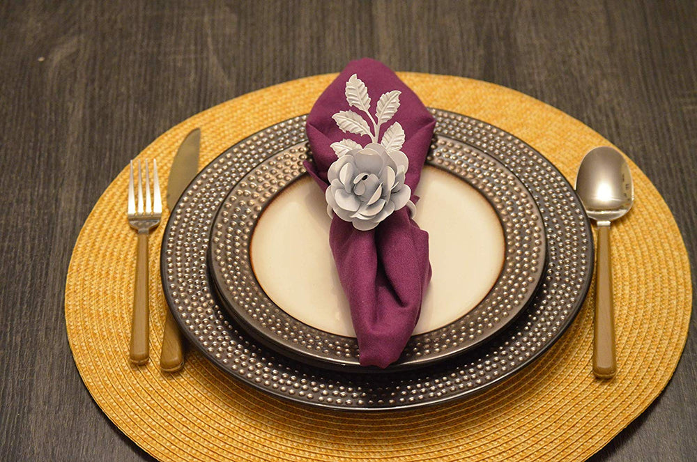 Set of four white rose napkin rings arranged elegantly on a dining table