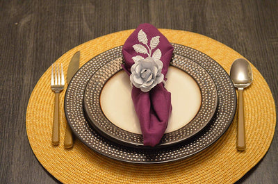 Set of four white rose napkin rings arranged elegantly on a dining table